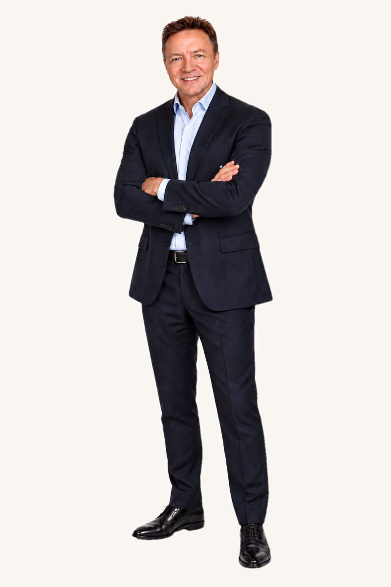 Grant de Graf, founder of The Legacy Project, standing full length in a navy suit with arms folded